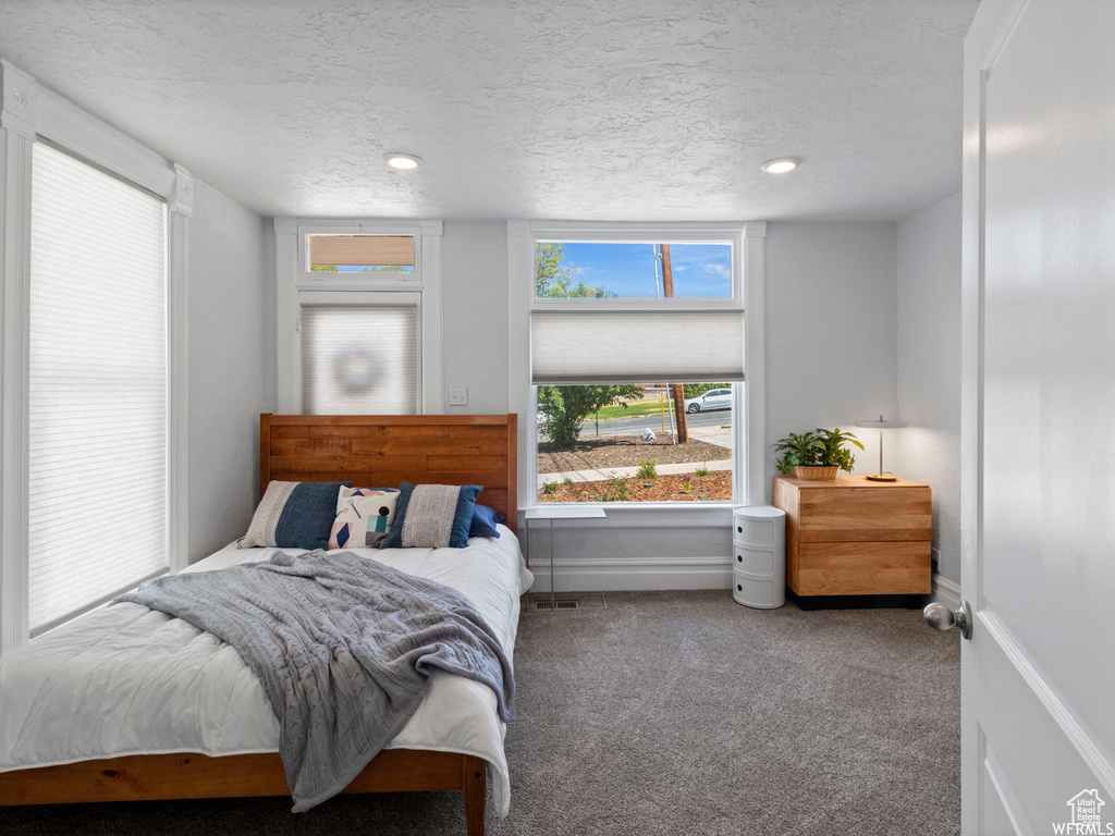 Carpeted bedroom featuring a textured ceiling, baseboards, and recessed lighting