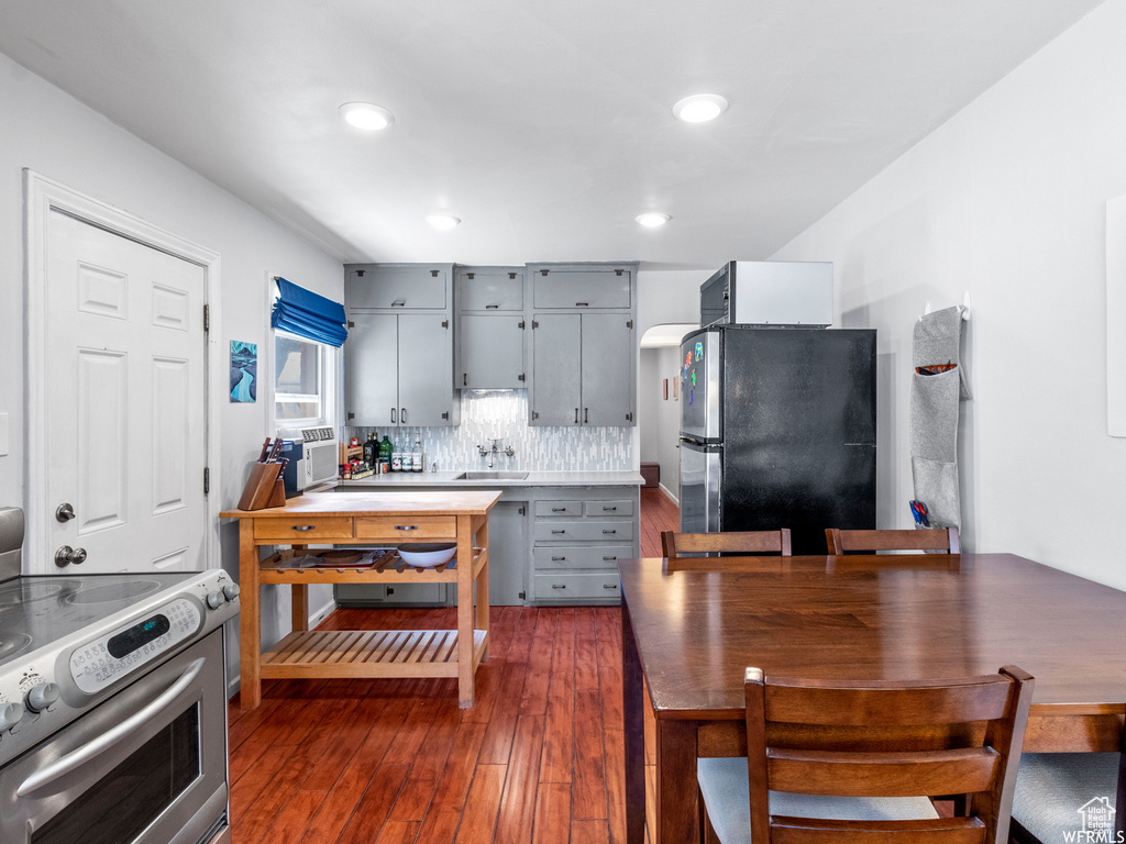 Kitchen with stainless steel appliances, gray cabinetry, dark wood finished floors, a sink, and recessed lighting