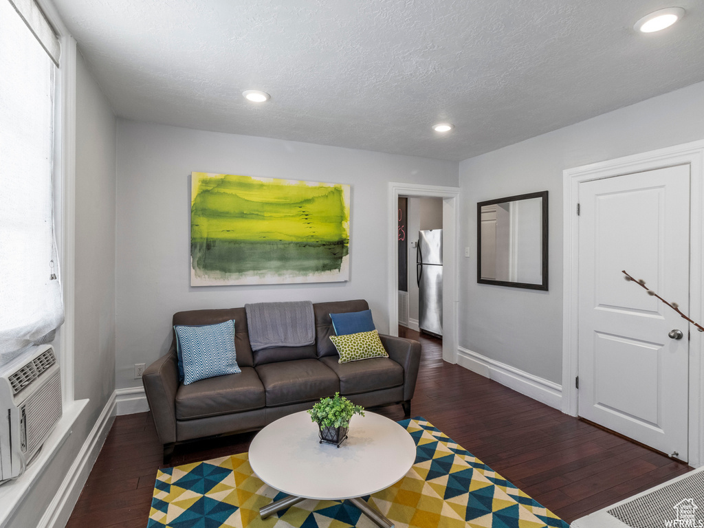 Living area featuring wood finished floors, recessed lighting, baseboards, and a textured ceiling