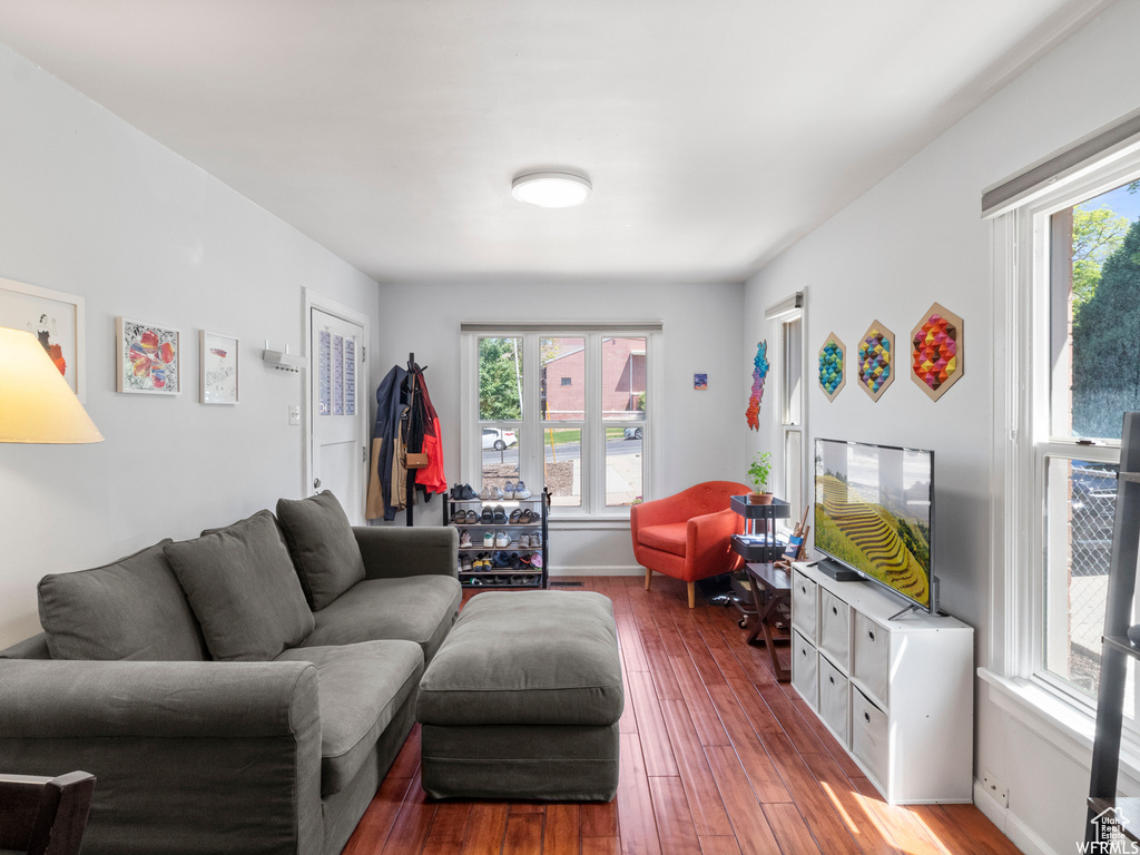 Living area featuring healthy amount of natural light, wood-type flooring, and baseboards