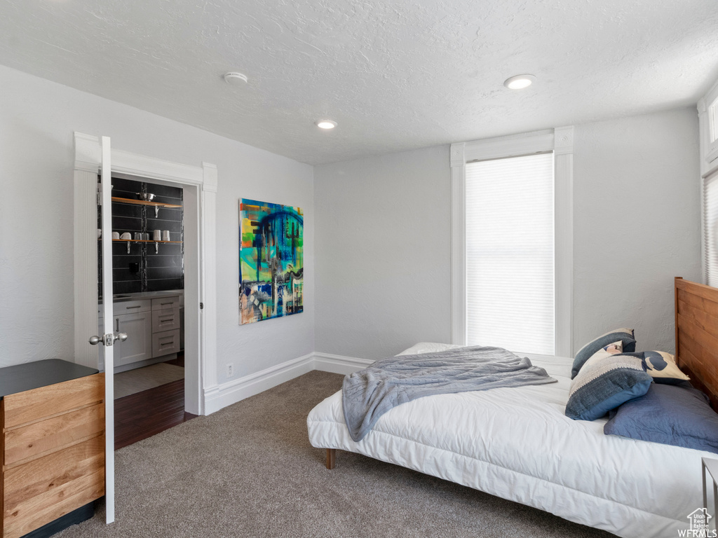 Carpeted bedroom with a textured ceiling, baseboards, and recessed lighting
