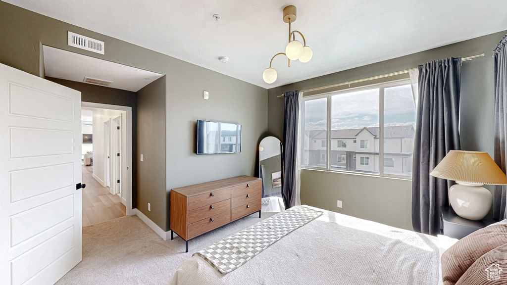 Bedroom with light colored carpet and baseboards