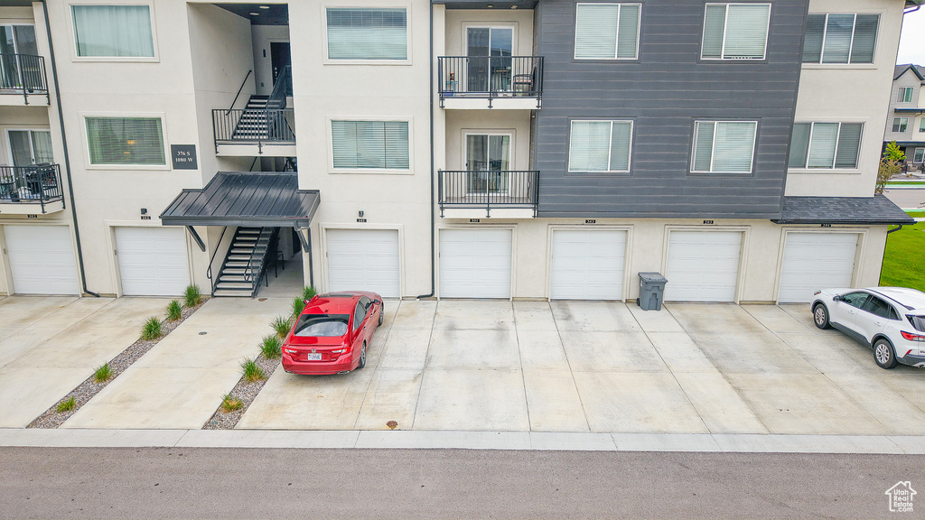 View of front of house with stucco siding, an attached garage, and driveway