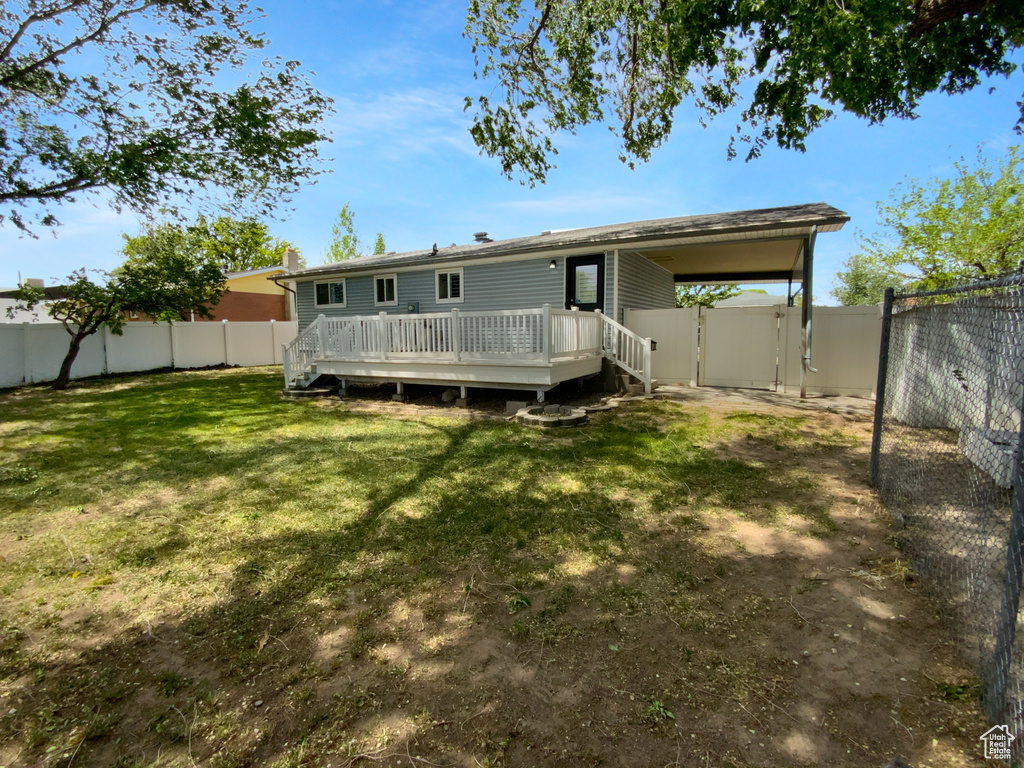 Rear view of house featuring a deck and a gate