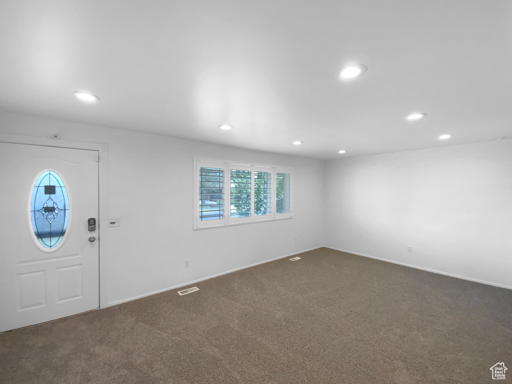 Entrance foyer featuring recessed lighting, dark colored carpet, and baseboards