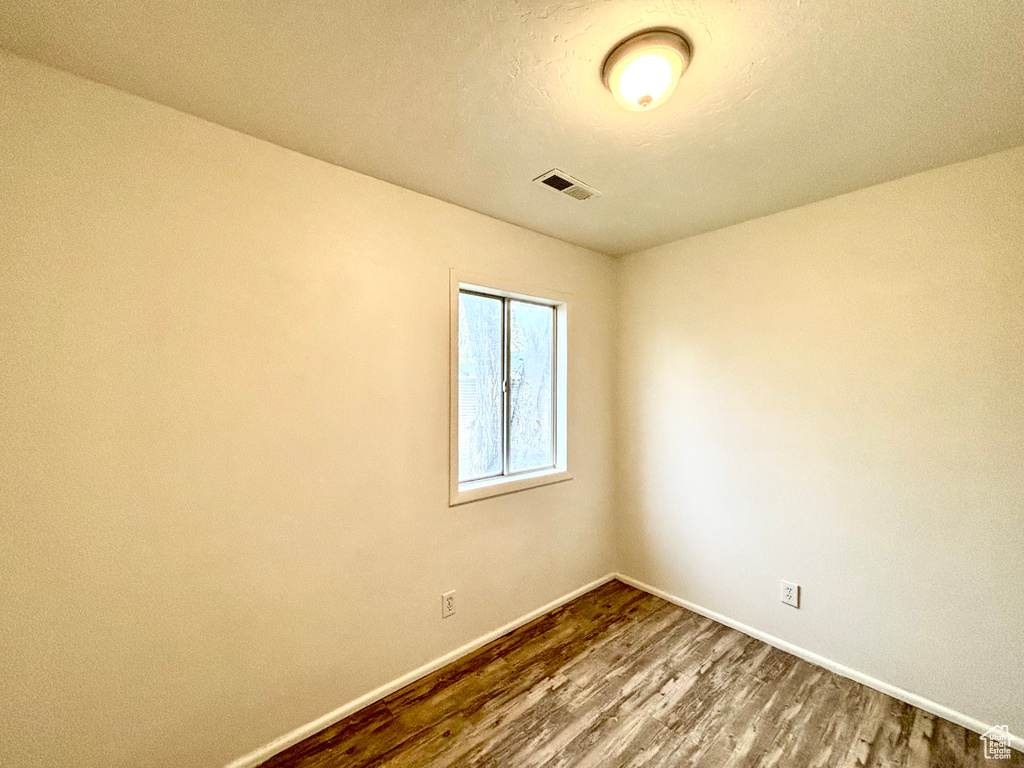 Unfurnished room with dark wood-style floors and baseboards