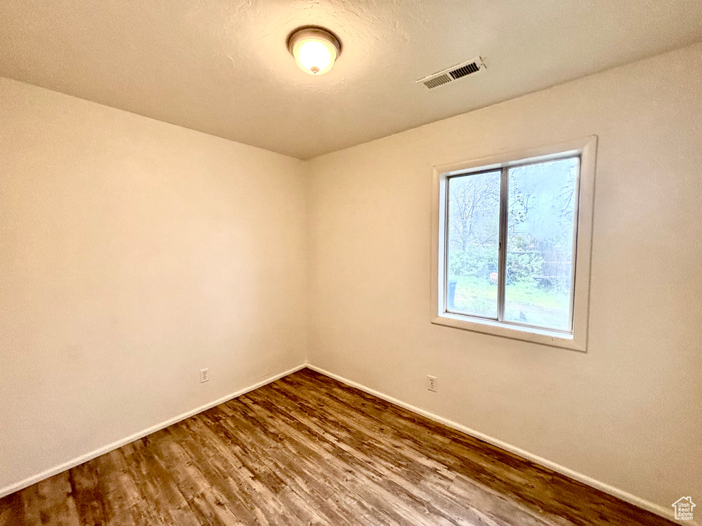 Unfurnished room featuring baseboards and wood finished floors