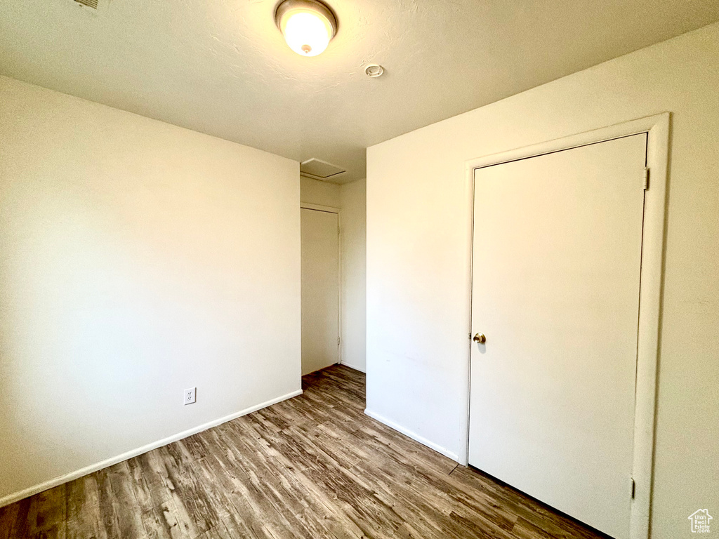 Unfurnished bedroom with wood finished floors and baseboards