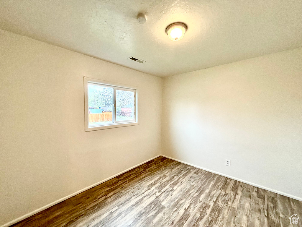 Spare room featuring wood finished floors and baseboards