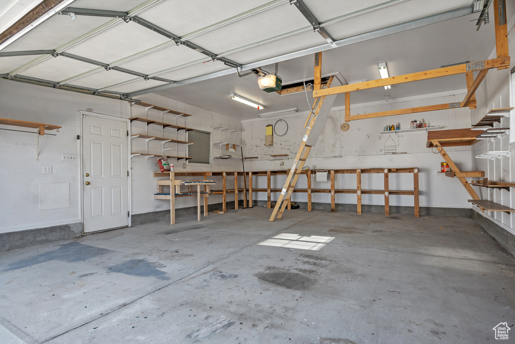 Garage with a garage door opener and a workshop area