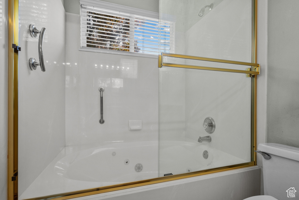 Full bath featuring shower / bath combination with glass door and toilet