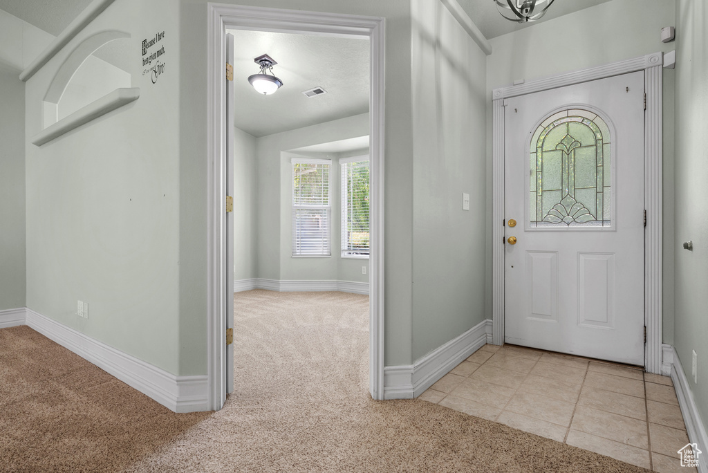 Carpeted foyer entrance featuring baseboards