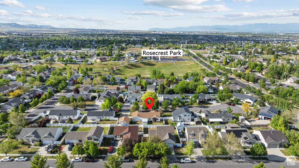 Aerial view of property and surrounding area with a mountain backdrop and nearby suburban area