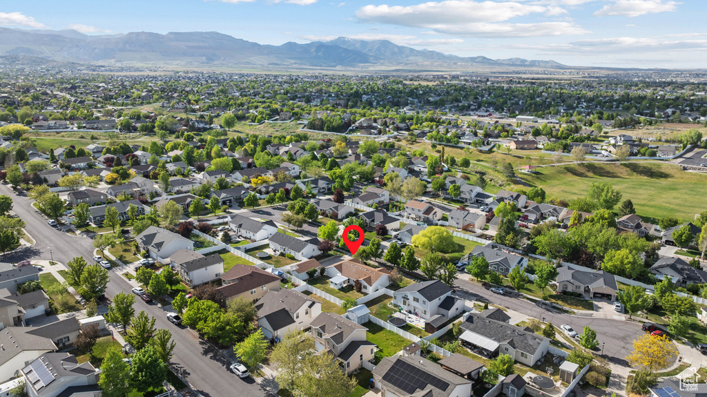 Aerial view of property and surrounding area with mountains and nearby suburban area