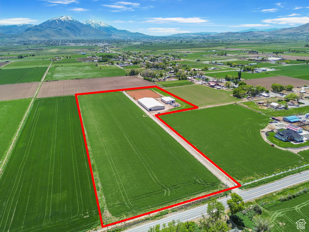 Aerial view of sparsely populated area with property parcel outlined and a mountain backdrop