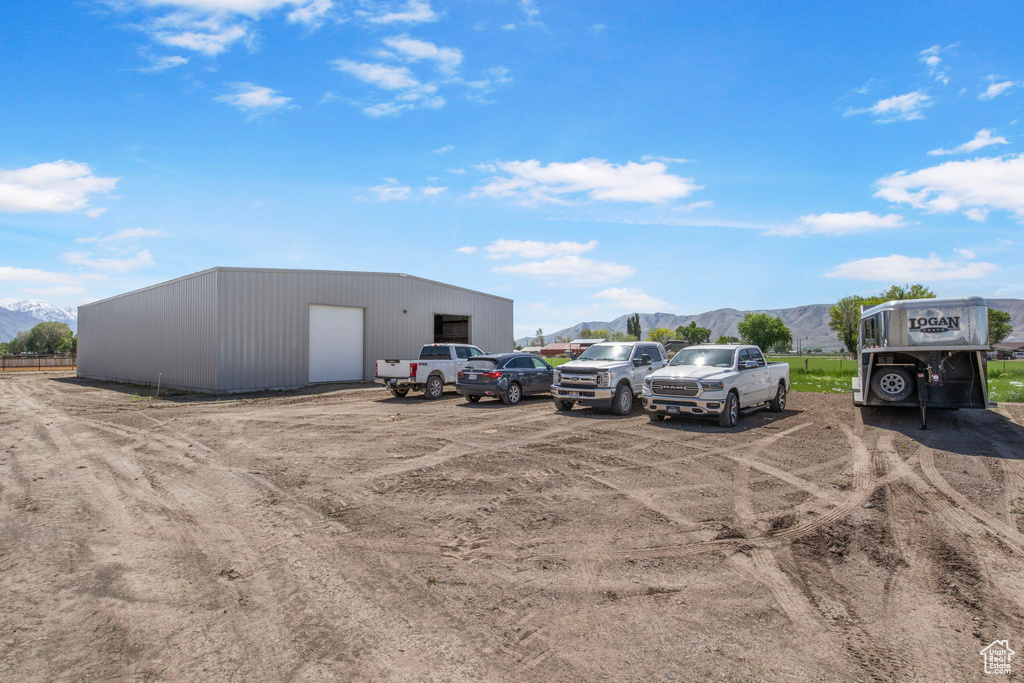 View of car parking with a mountain view and a garage