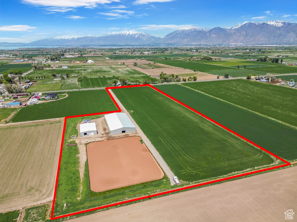 Aerial view of sparsely populated area featuring property boundaries highlighted and a mountain backdrop