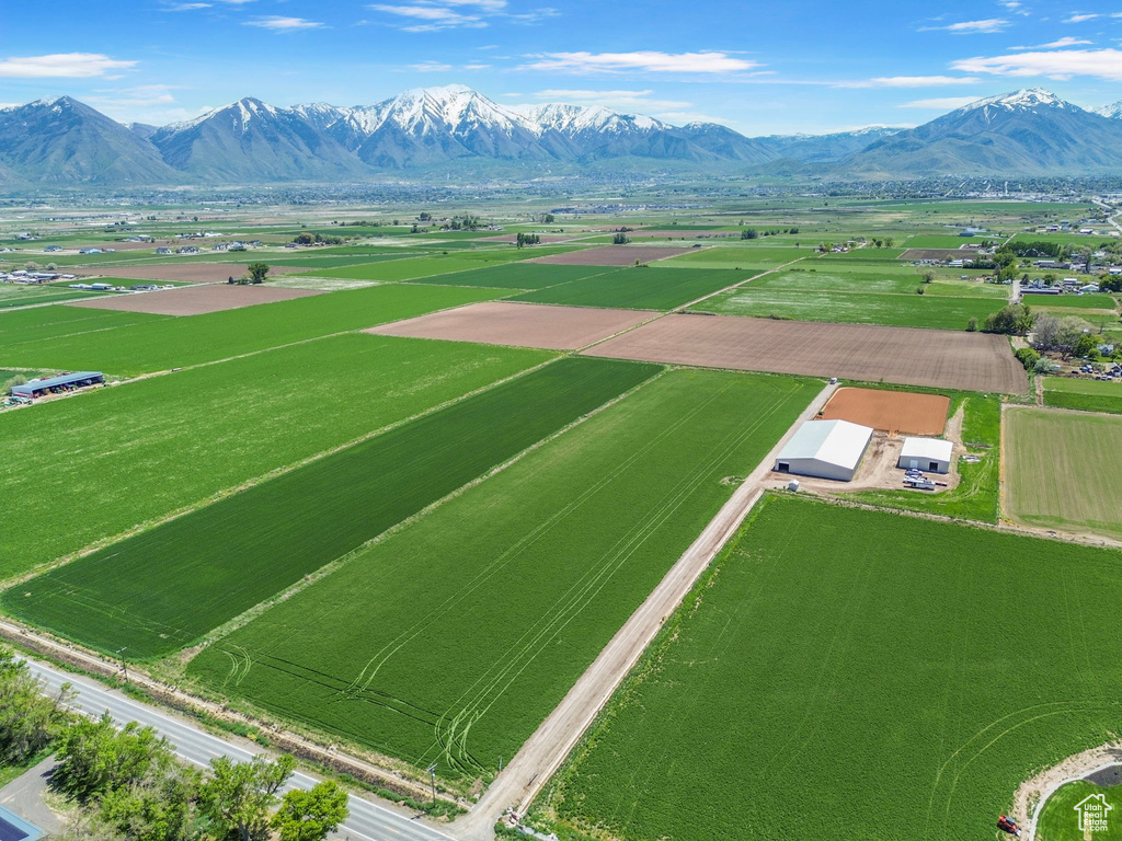 Aerial view of sparsely populated area featuring a mountainous background and abundant farmland