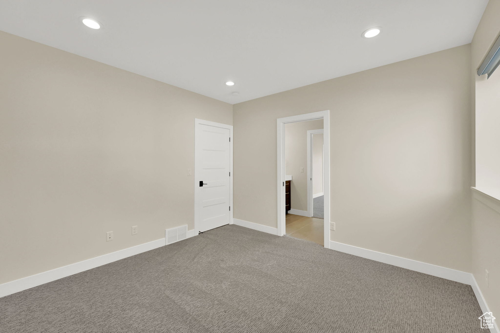 Carpeted spare room with recessed lighting and baseboards
