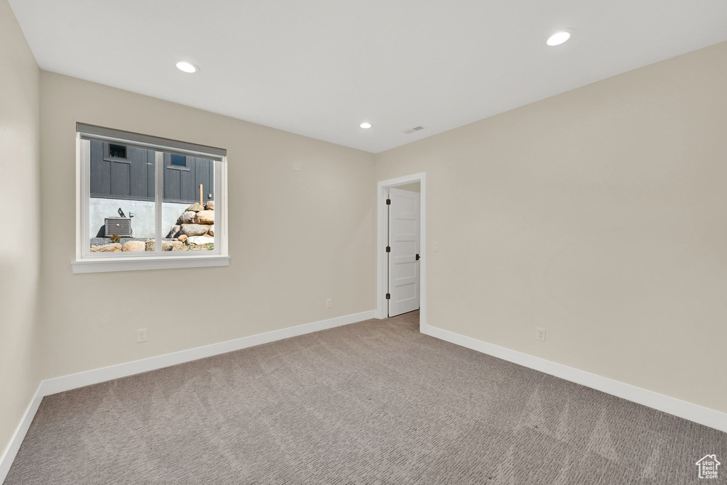 Carpeted empty room with baseboards and recessed lighting