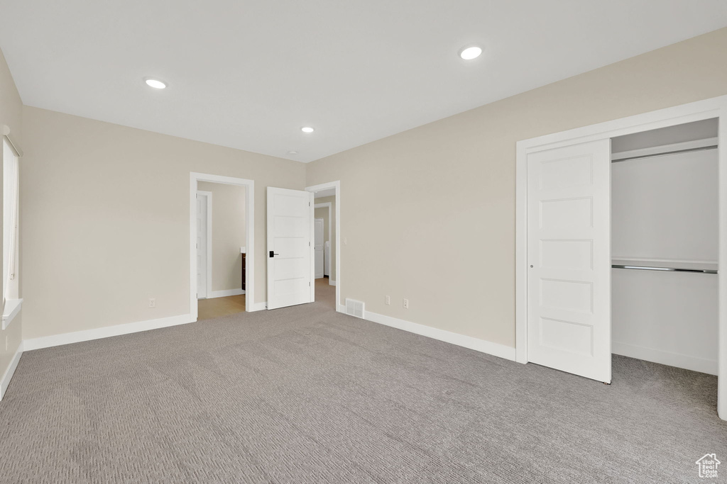 Unfurnished bedroom with carpet floors, recessed lighting, baseboards, and a closet