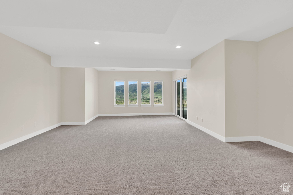 Carpeted empty room featuring recessed lighting and baseboards