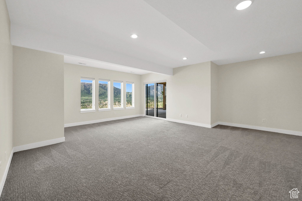 Carpeted empty room with baseboards and recessed lighting