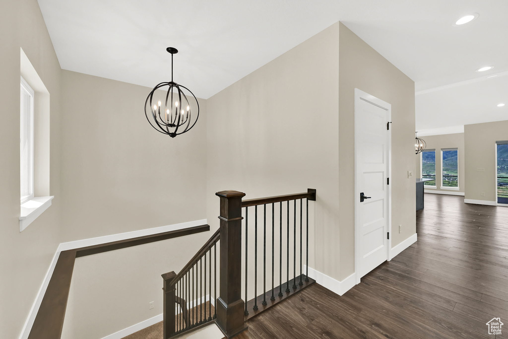 Stairs featuring a chandelier, wood finished floors, baseboards, and recessed lighting