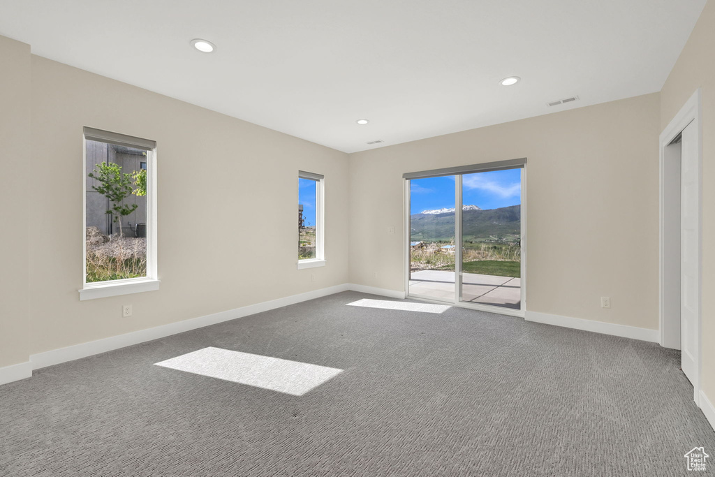 Carpeted spare room with baseboards and recessed lighting