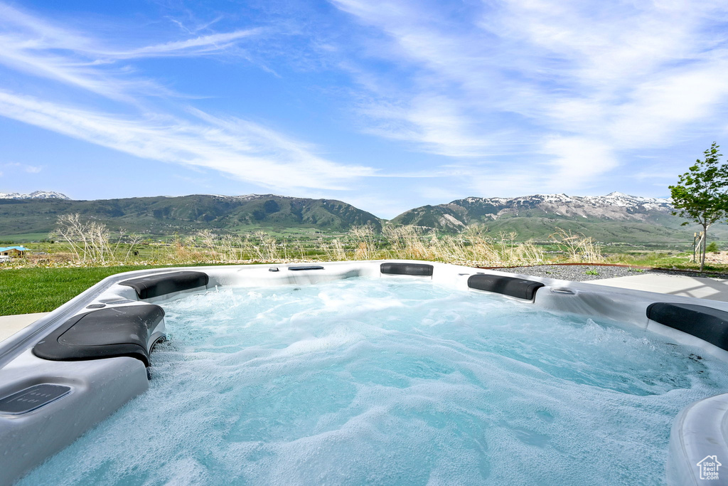 View of swimming pool with a mountain view and a hot tub