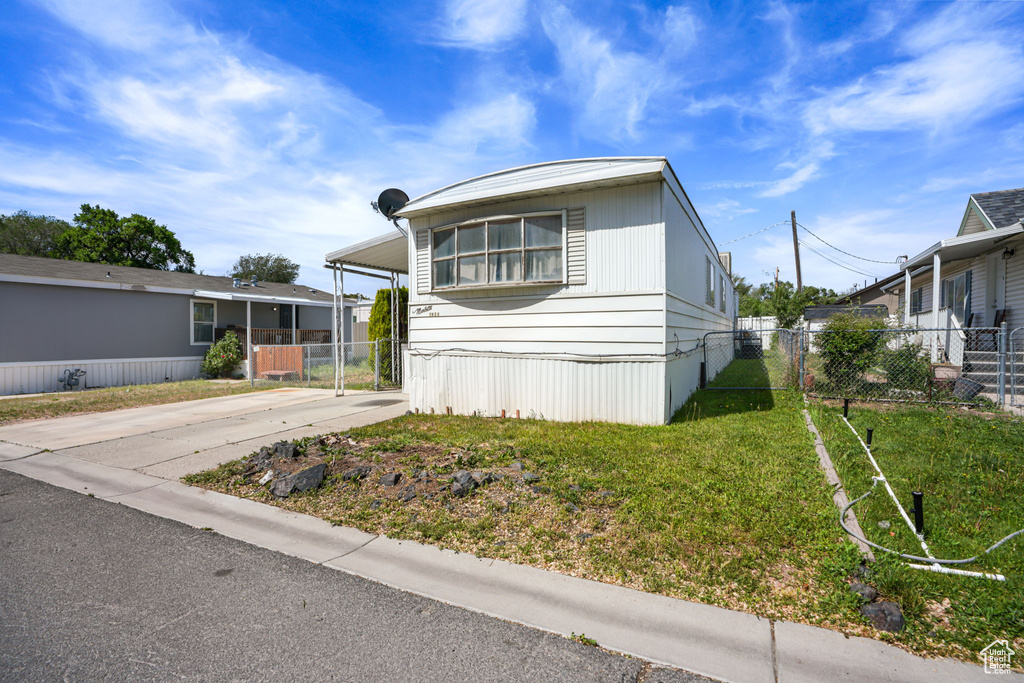 Manufactured / mobile home with concrete driveway and an attached carport