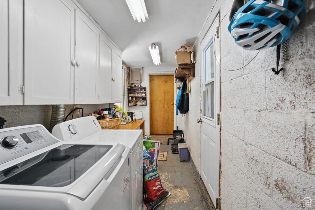 Clothes washing area featuring washer and dryer and cabinet space