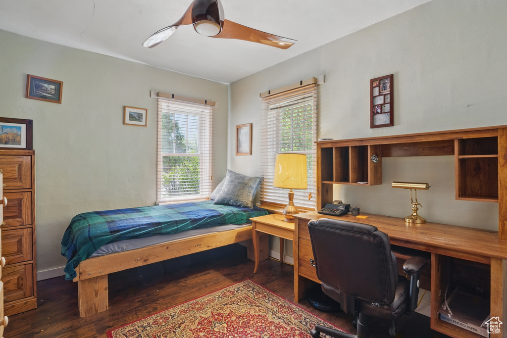 Bedroom with wood finished floors, an office area, and ceiling fan
