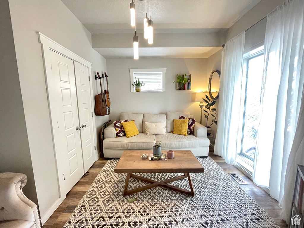 Living area with dark wood-style floors and beamed ceiling
