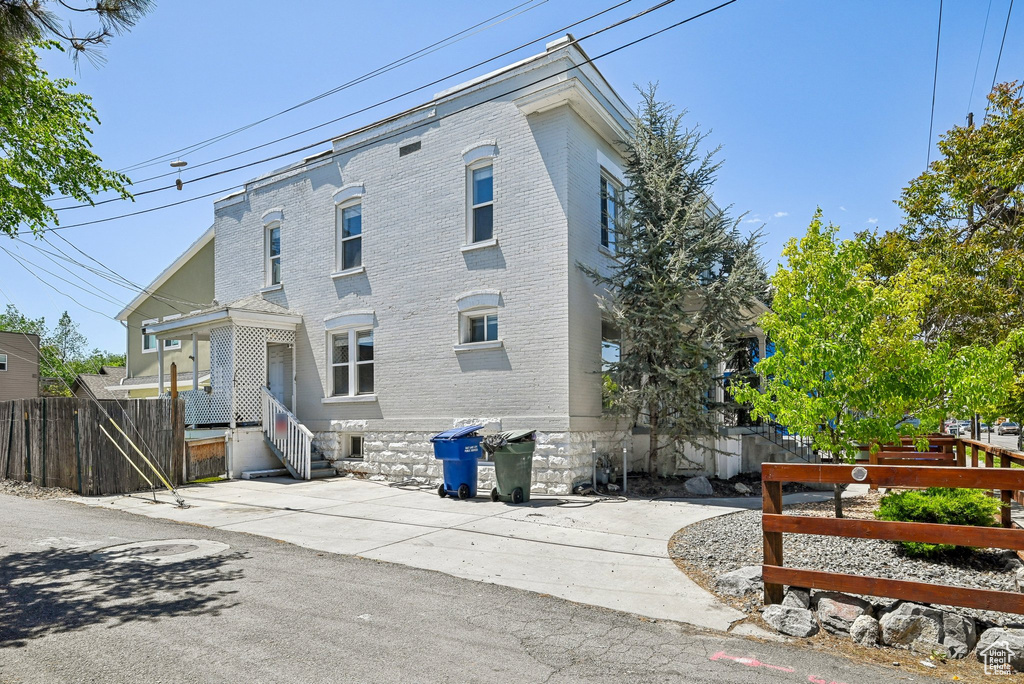 View of side of property featuring brick siding and fence