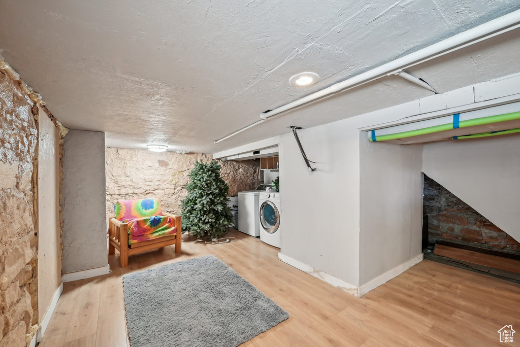 Laundry area with washer and dryer, wood finished floors, and baseboards