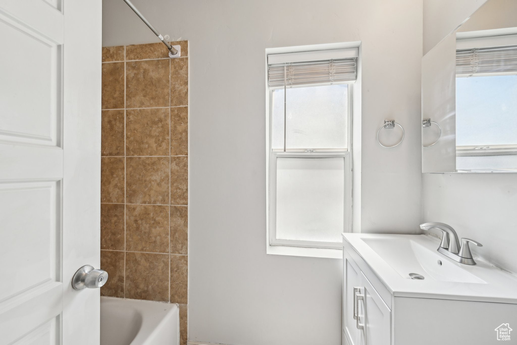 Bathroom with plenty of natural light, vanity, and bathtub / shower combination