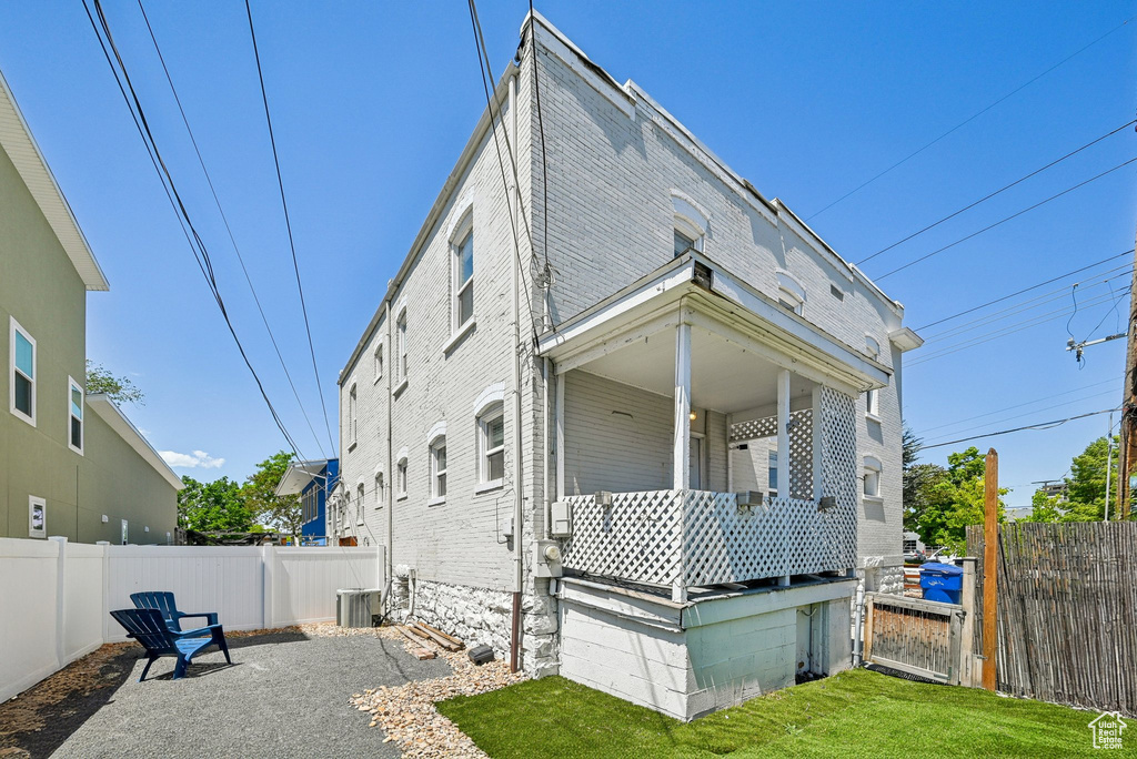 Rear view of house featuring a fenced backyard and covered porch