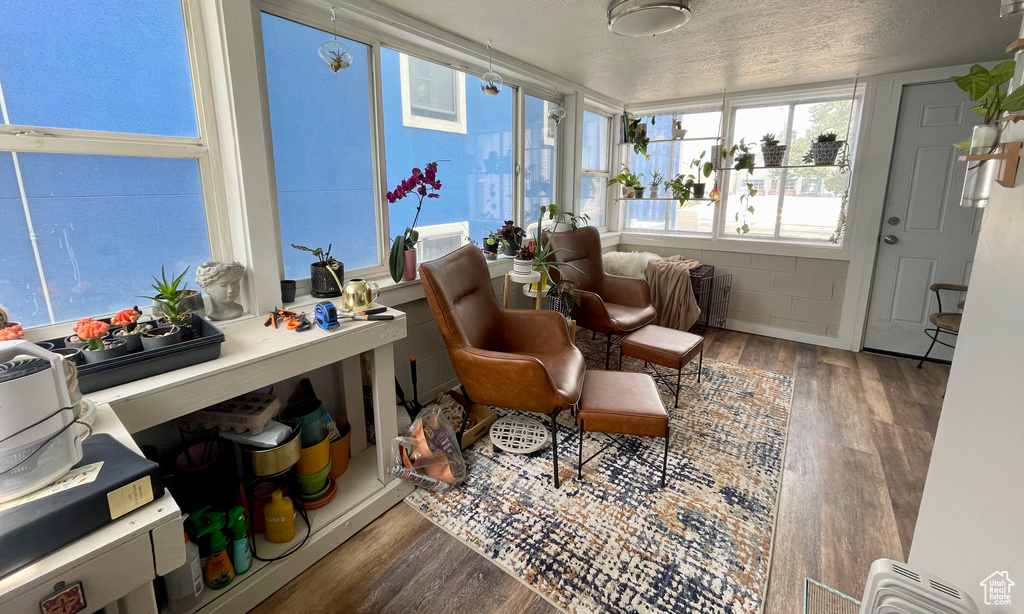 Sunroom with wood finished floors and a textured ceiling