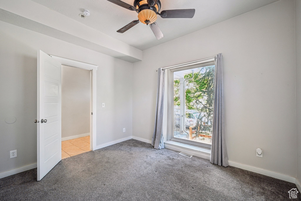 Spare room featuring carpet, a ceiling fan, and baseboards