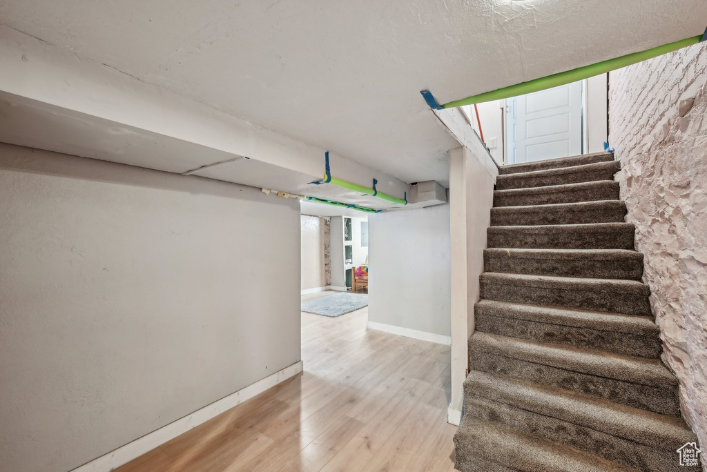 Stairs featuring wood finished floors and baseboards