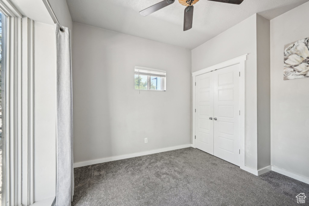 Unfurnished bedroom with carpet flooring, baseboards, a ceiling fan, and a closet