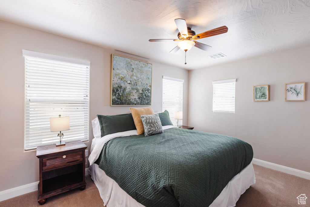 Carpeted bedroom with baseboards and ceiling fan