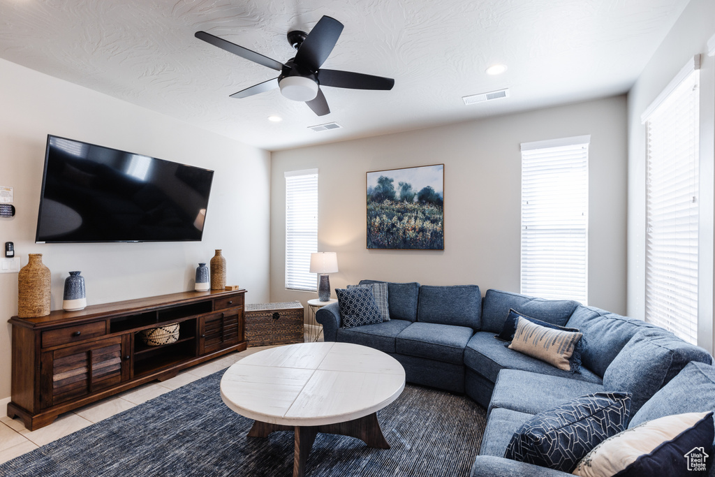 Living area featuring light tile patterned floors, a ceiling fan, healthy amount of natural light, and recessed lighting