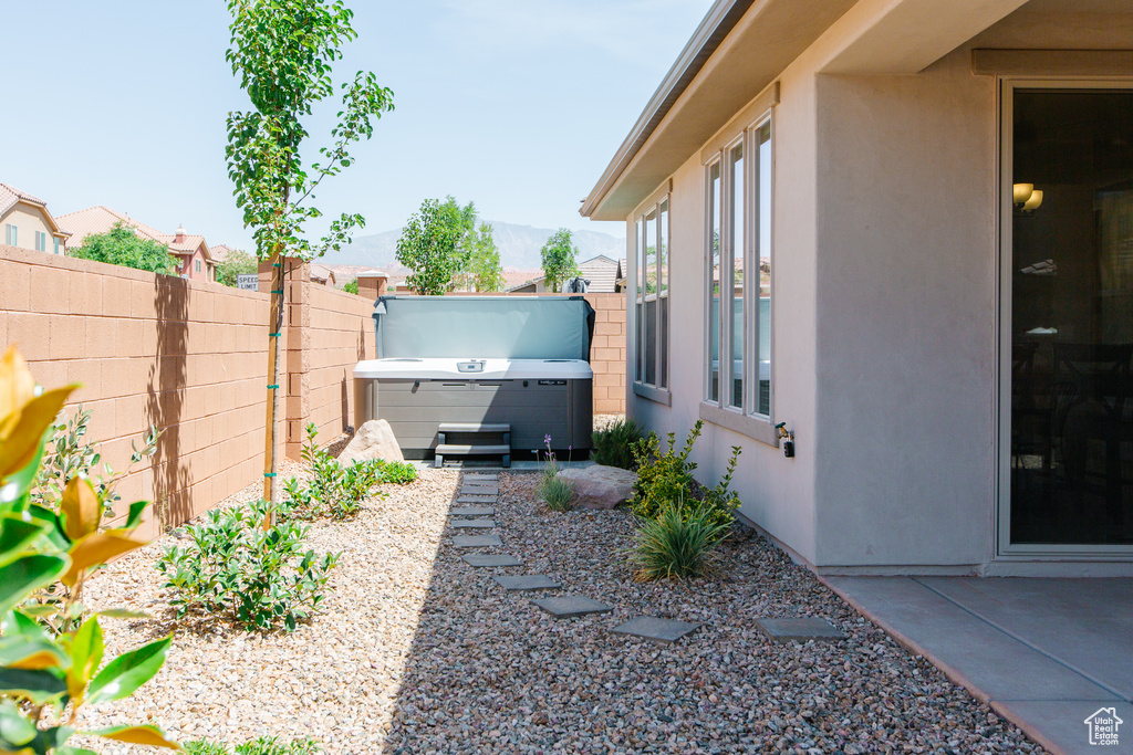 View of yard featuring fence, a patio area, a mountain view, and a hot tub