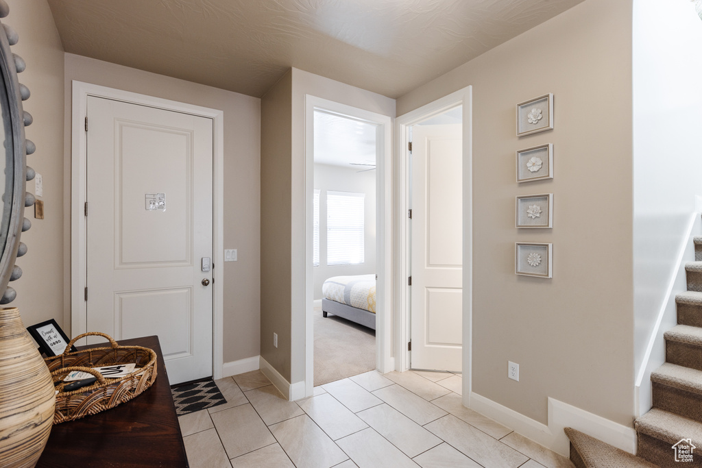 Entryway featuring stairs, baseboards, and light tile patterned floors