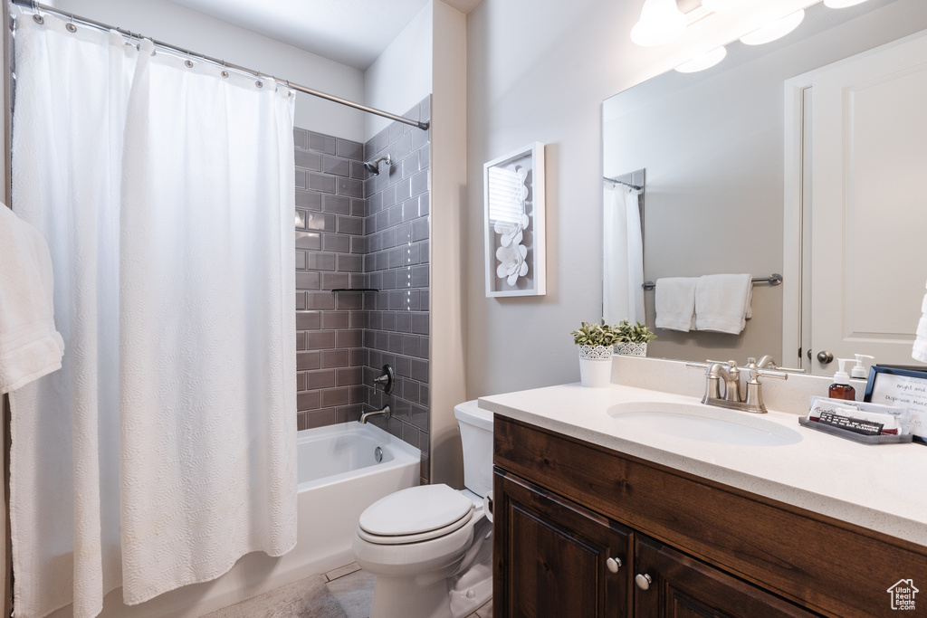 Bathroom featuring toilet, shower / bath combo, vanity, and tile patterned floors