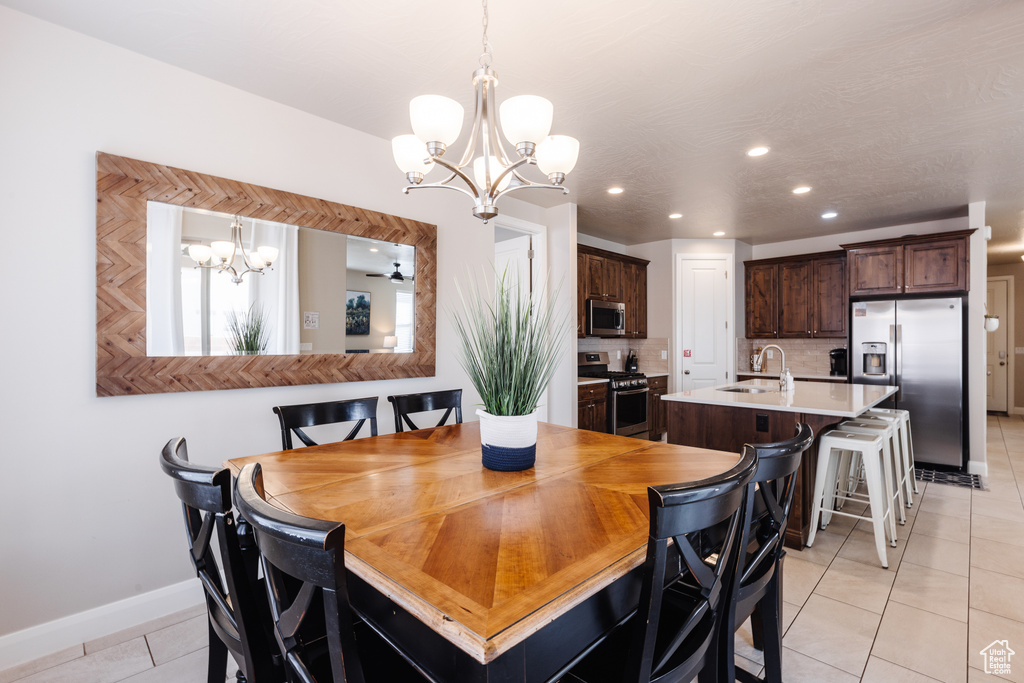 Dining area featuring a chandelier, light tile patterned floors, baseboards, and recessed lighting