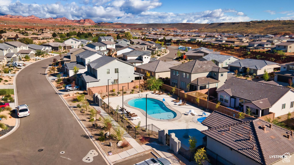 Aerial view of residential area featuring a pool area and a mountain backdrop