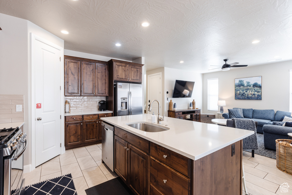 Kitchen featuring stainless steel appliances, a sink, tasteful backsplash, recessed lighting, and light countertops